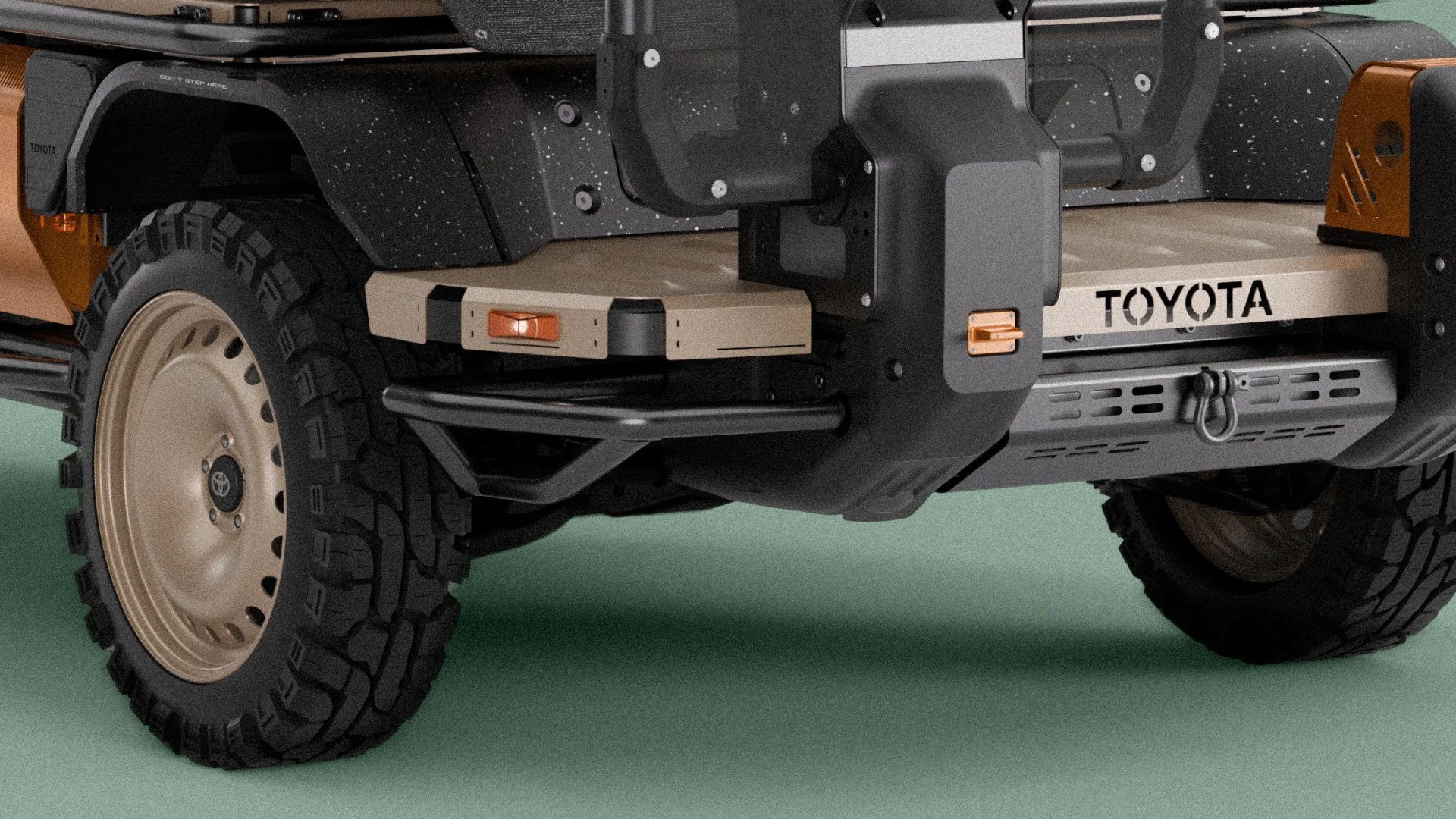 Rear section of a Toyota vehicle with beige steel wheels, off-road tires, and a beige rear bumper with black and orange accents.