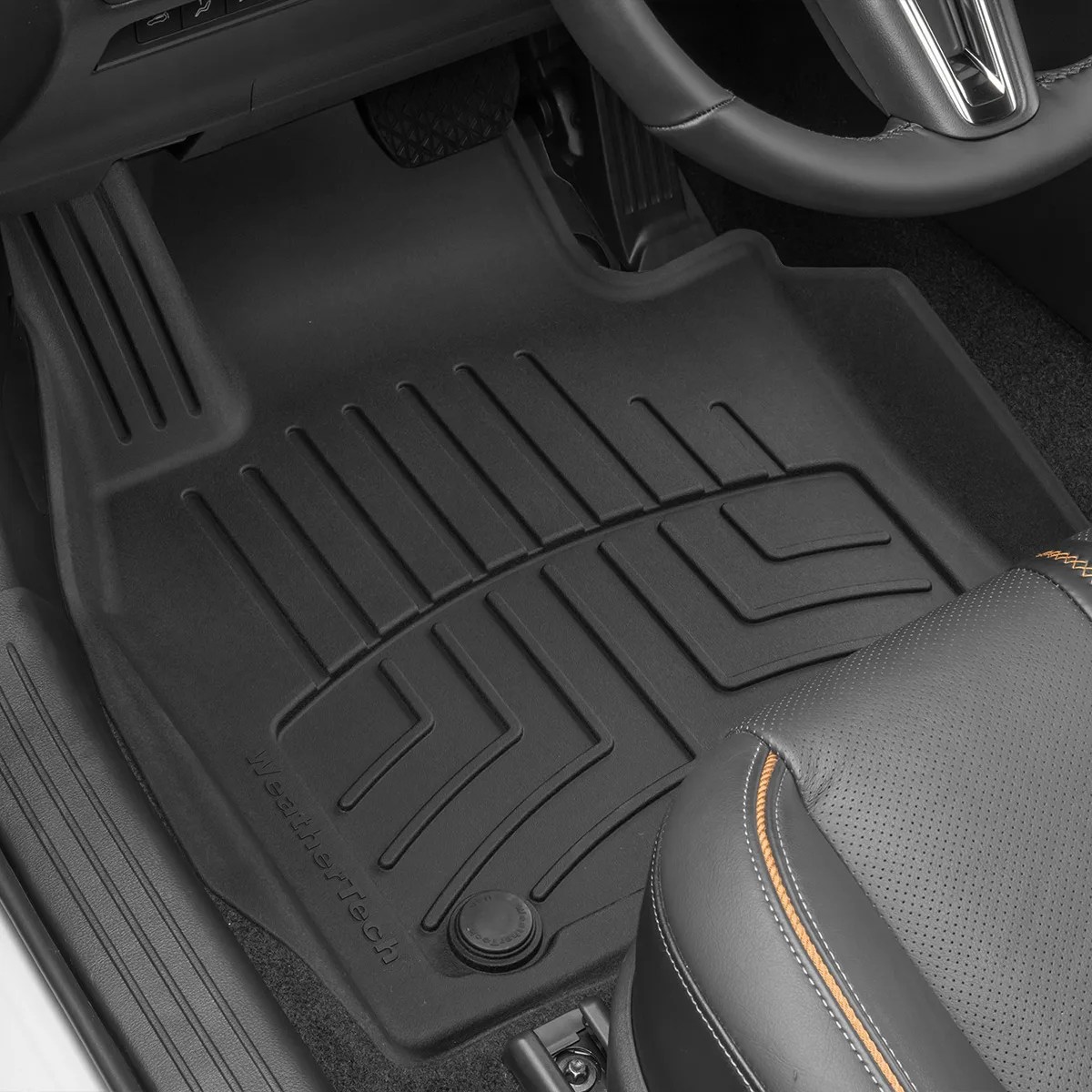 Black WeatherTech molded rubber car floor mat installed on the driver's side with textured grooves and a securing clip.