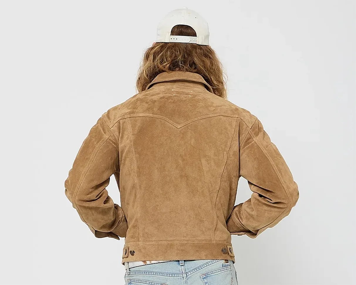 Light brown suede jacket with buttoned adjustable waist straps worn by a person facing away.