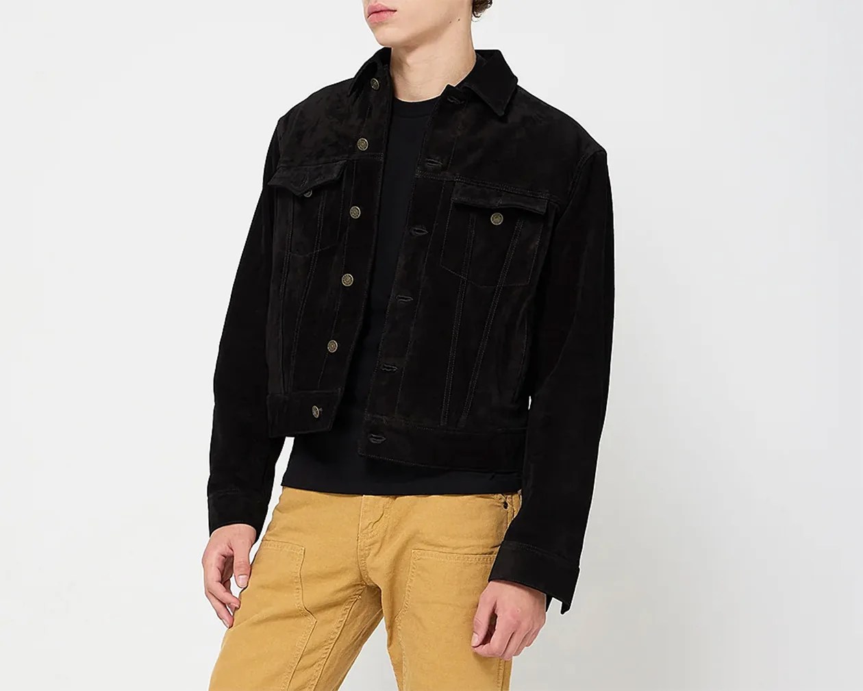 Black corduroy jacket with button front and flap chest pockets worn over a black shirt.