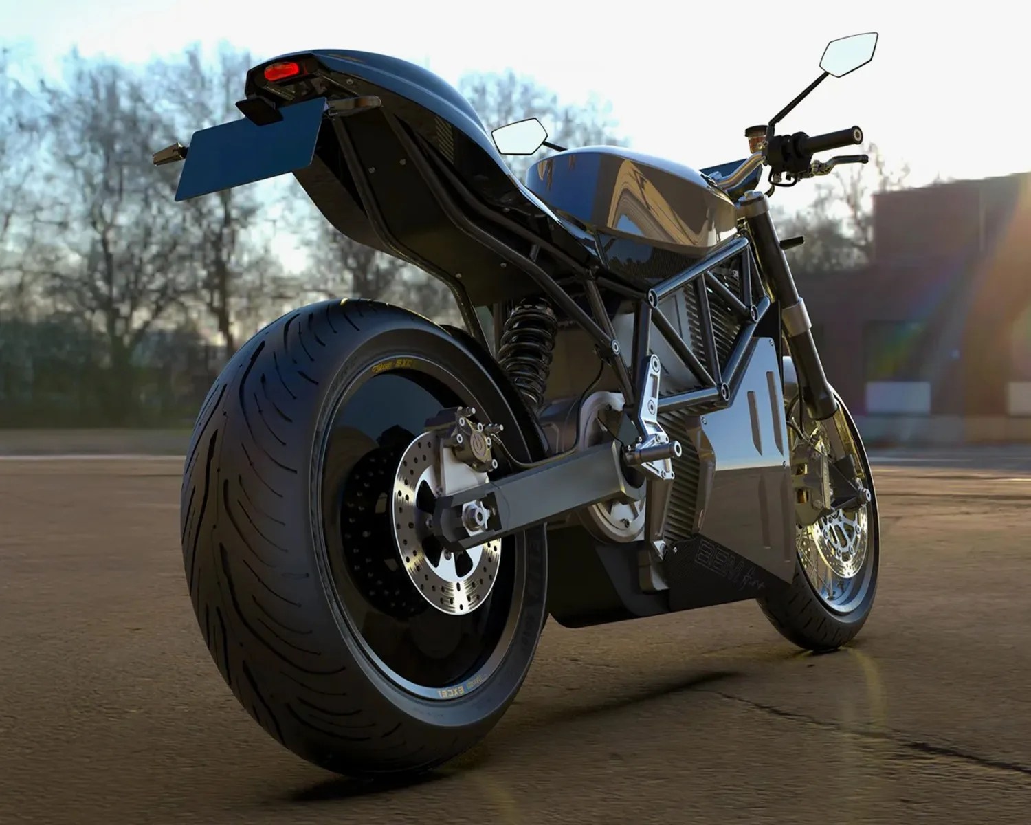 Glossy black and silver electric motorcycle with wide rear tire parked on a paved surface at sunset.