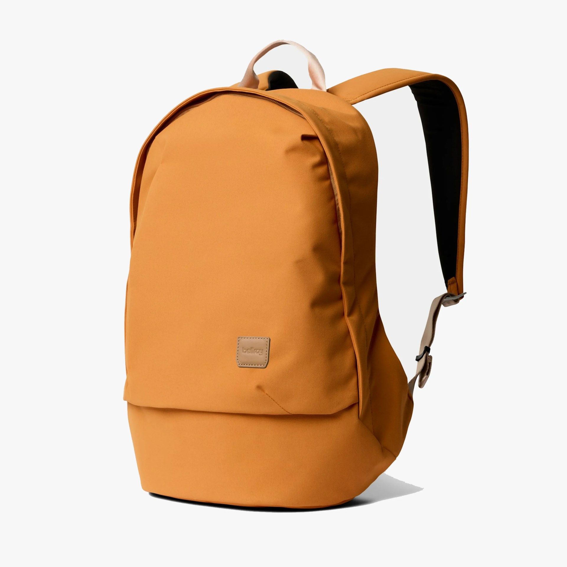 Mustard yellow backpack with padded shoulder straps and a small leather logo patch on the front.