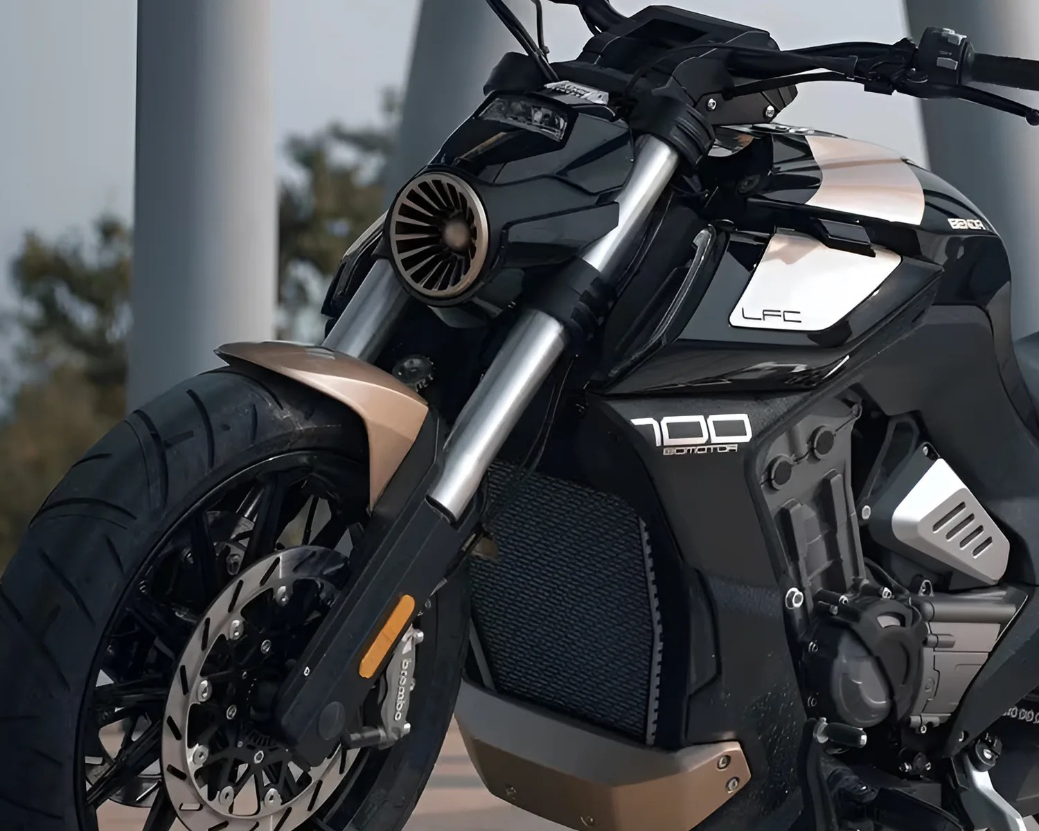 Close-up of a black and bronze electric motorcycle front wheel and fork with "LFC" and "700" branding on the body.