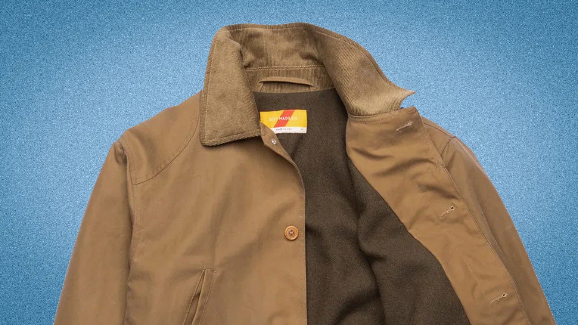 Brown canvas jacket with corduroy collar and dark fleece lining on a blue background.