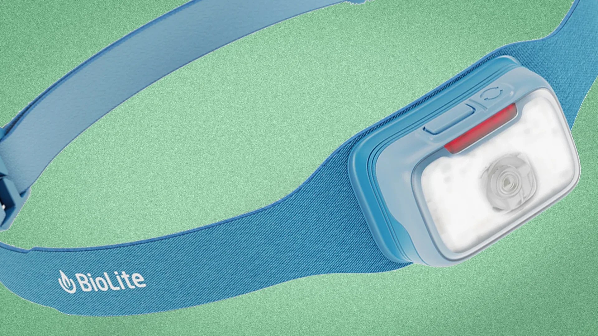 Blue BioLite headlamp with adjustable fabric strap and white LED light on green background.