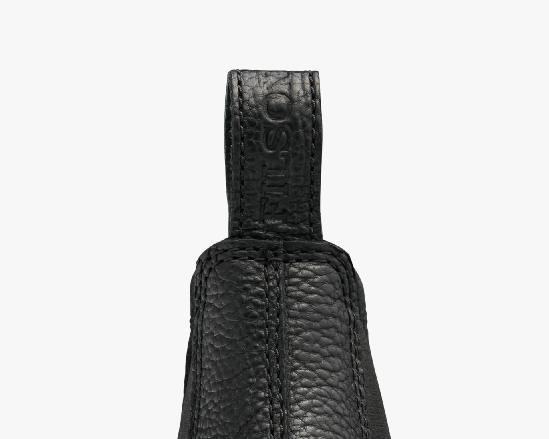 Close-up of a black textured leather pull tab with the embossed word "FILSON.
