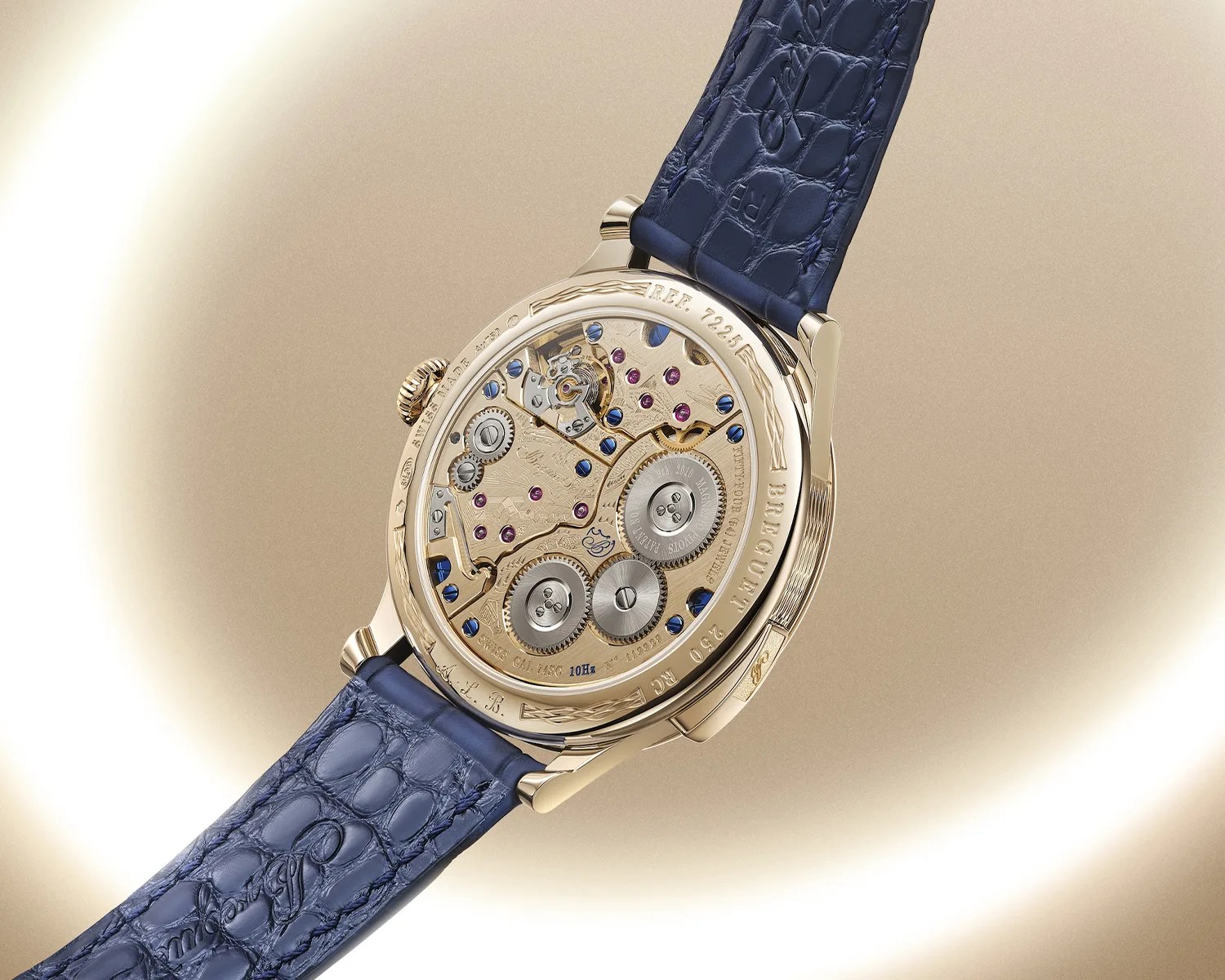 Gold watch back showing intricate mechanical movement with blue screws and purple jewels, attached to a blue alligator leather strap.