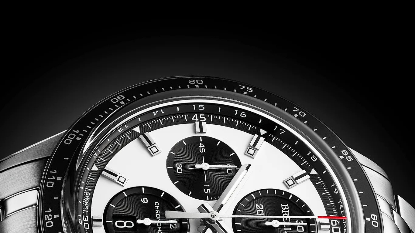 Close-up of a silver chronograph watch with a white dial, black subdials, and a black tachymeter bezel.