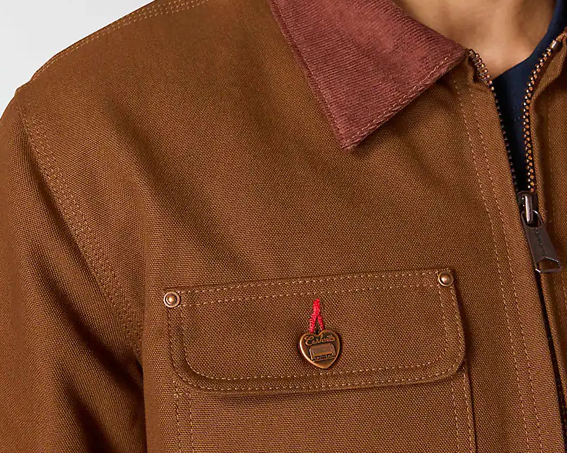 Brown canvas jacket with a corduroy collar, chest pocket, and heart-shaped metal button.