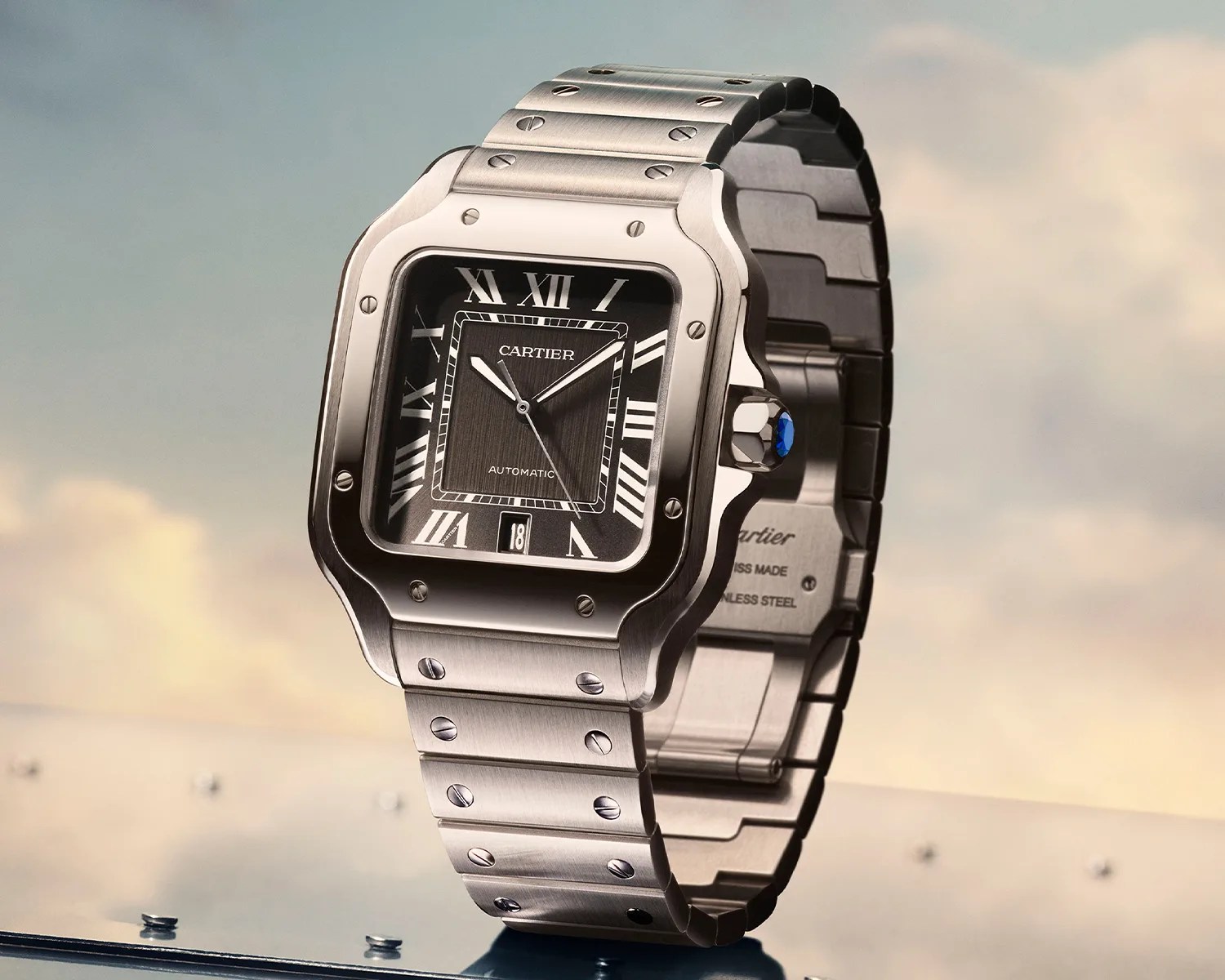 Stainless steel Cartier wristwatch with black square dial, Roman numerals, and metal bracelet.