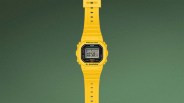Yellow Casio G-Shock digital watch with black and gray face on a green background.