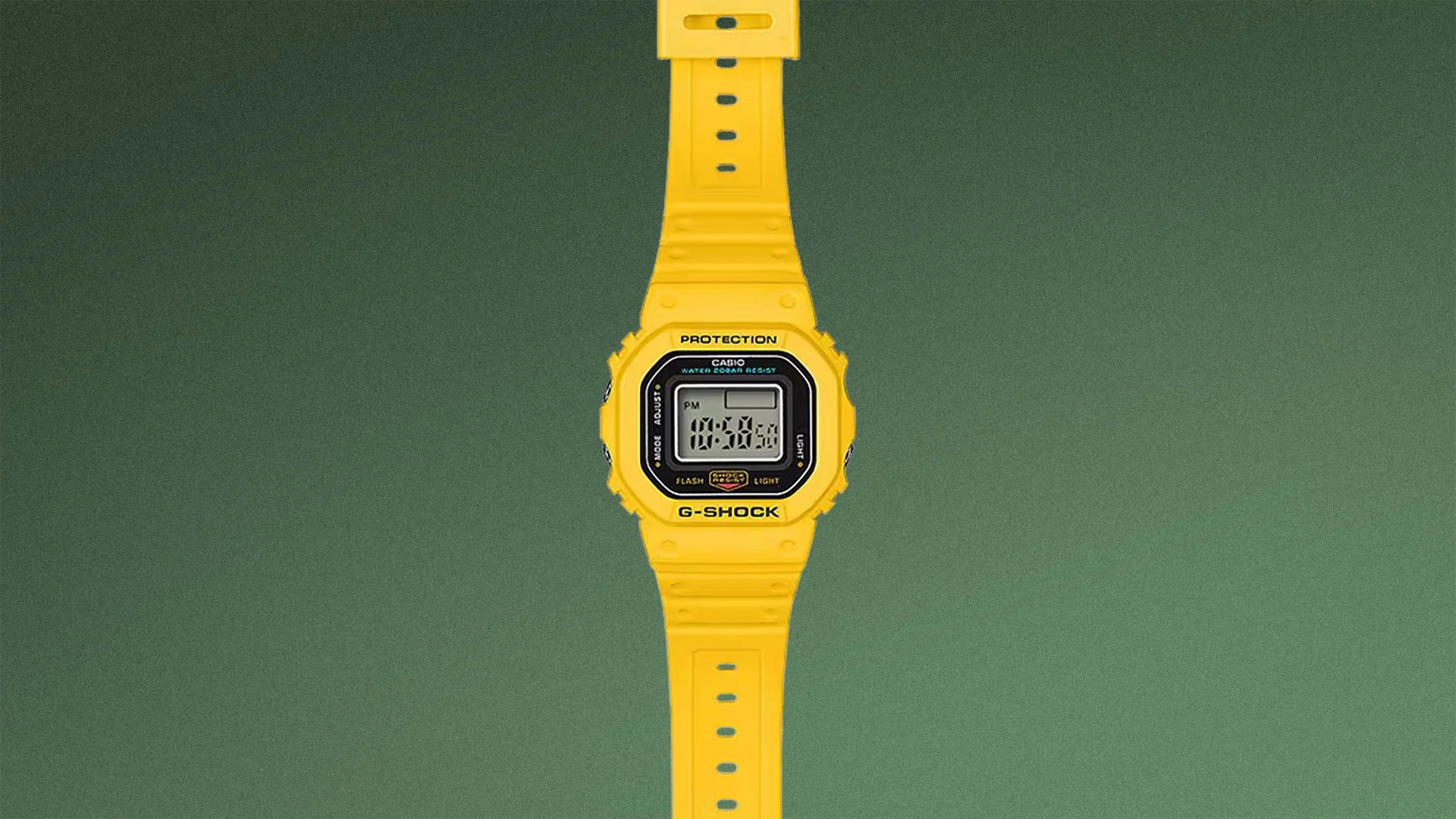 Yellow Casio G-Shock digital watch with black and gray face on a green background.