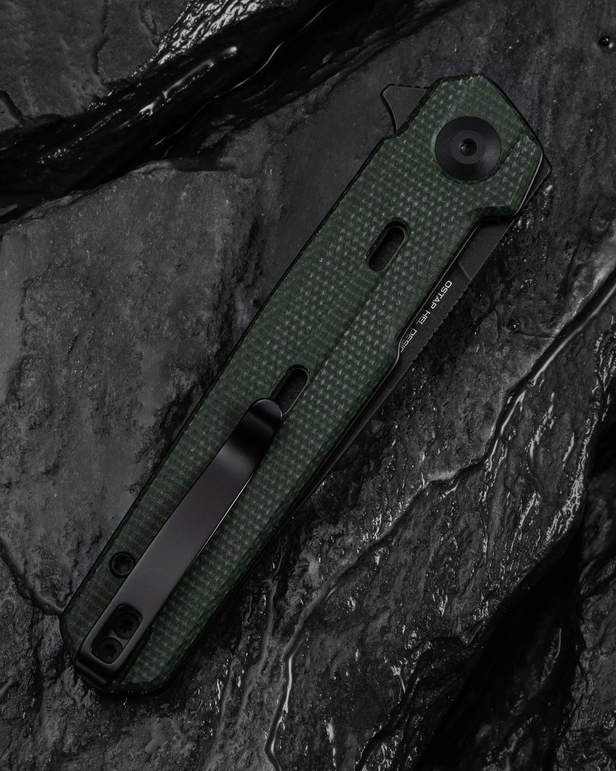Folded dark green textured pocket knife with black clip on wet black stone surface.