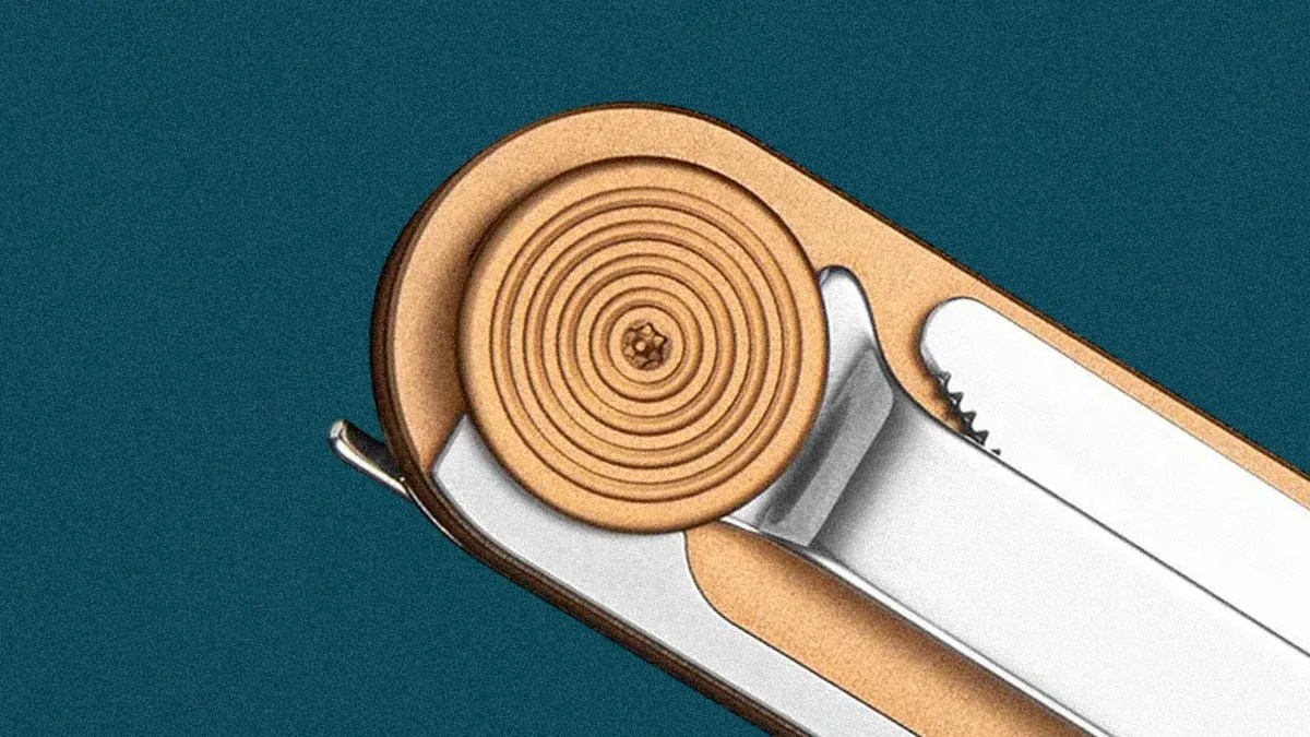 Close-up of a metallic multi-tool with a circular textured knob and a serrated blade on a teal background.