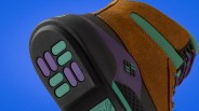 Close-up of the sole and side of a brown, purple, and teal sneaker with textured rubber sole and patterned laces.