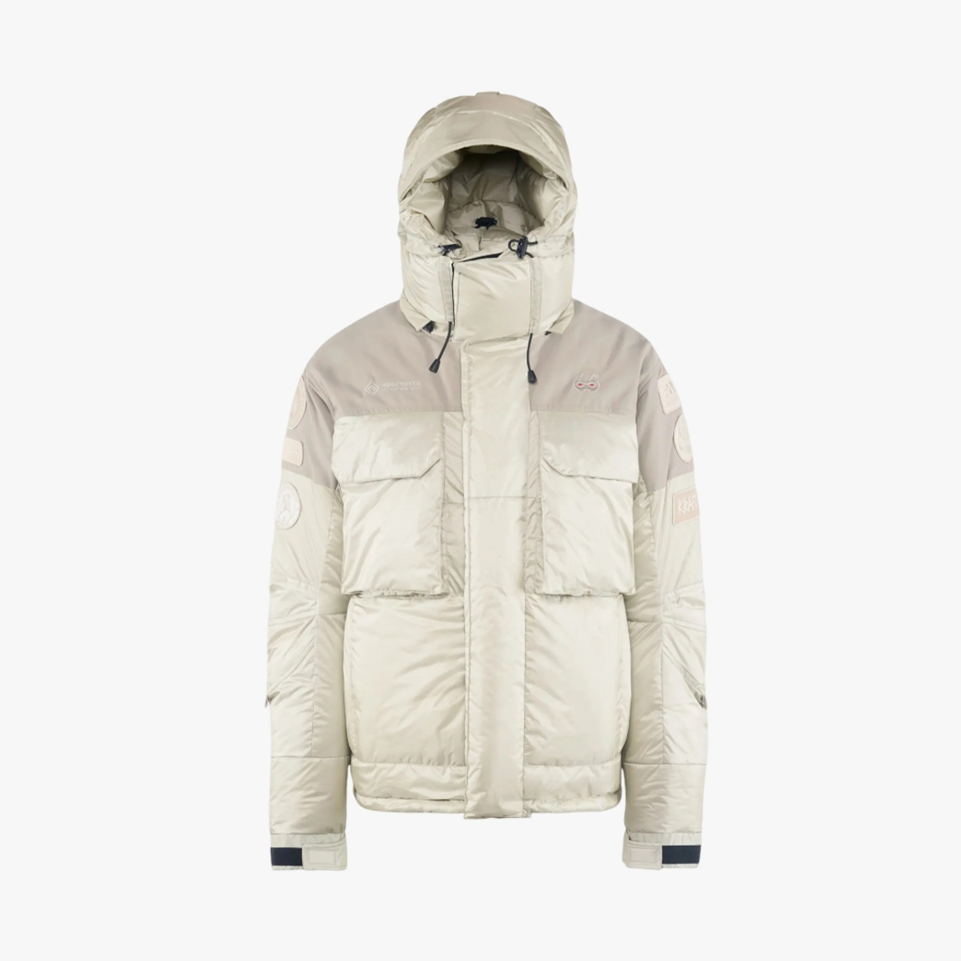 Beige padded winter jacket with hood, multiple front pockets, and patches on sleeves.