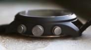 Close-up of a black watch case side with three textured silver pushers