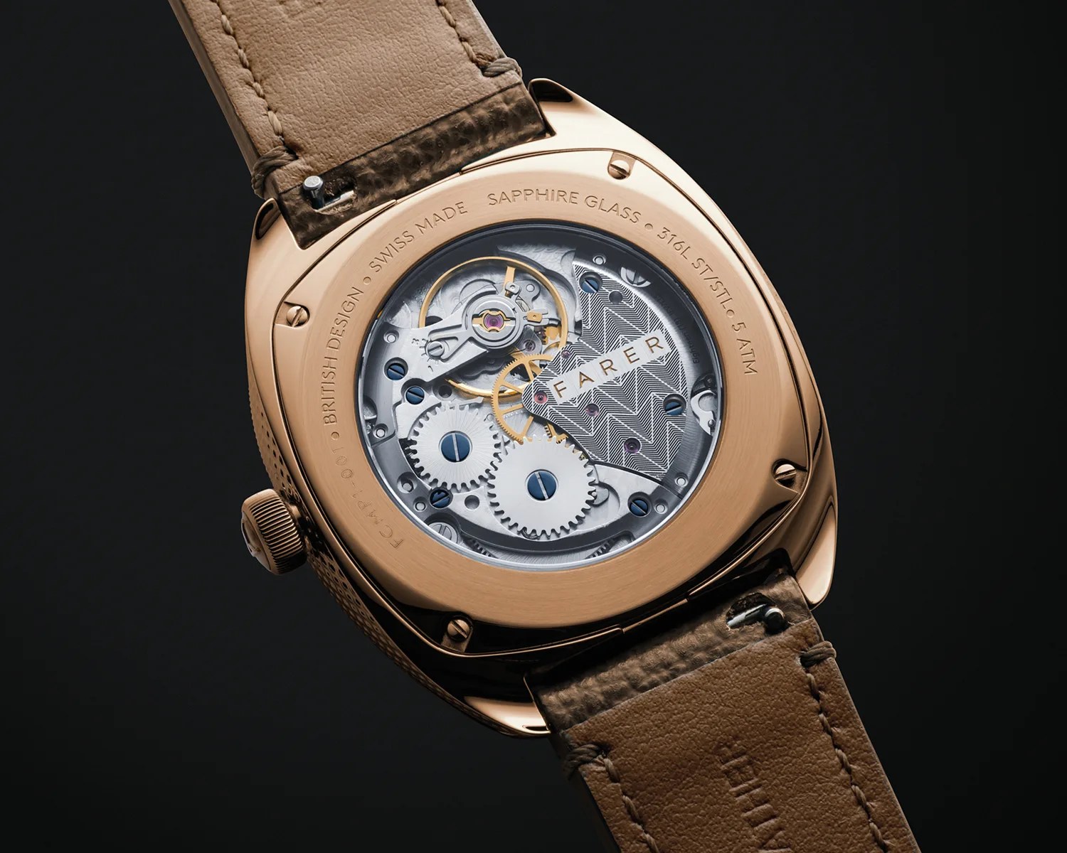 Rose gold watch case back with visible mechanical movement and brown leather strap.