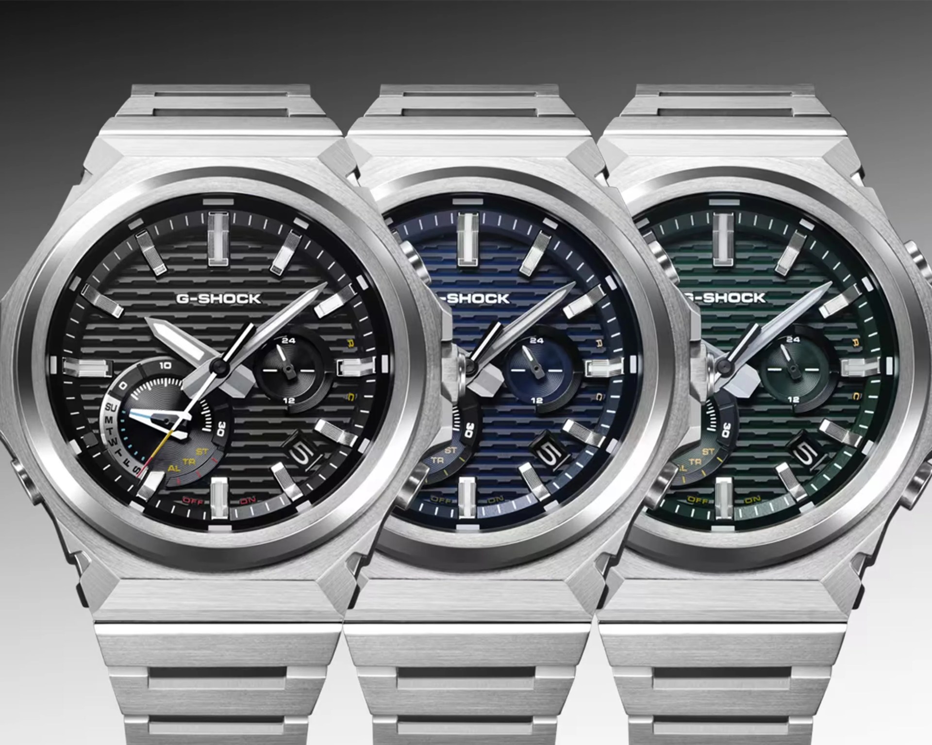 Three G-Shock watches with stainless steel bands and octagonal bezels, featuring black, blue, and green textured dials.