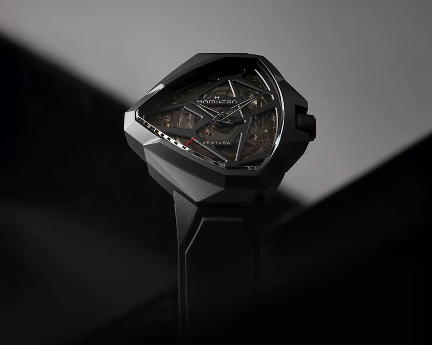 Black Hamilton Ventura wristwatch with a geometric case and skeleton dial on a black strap.