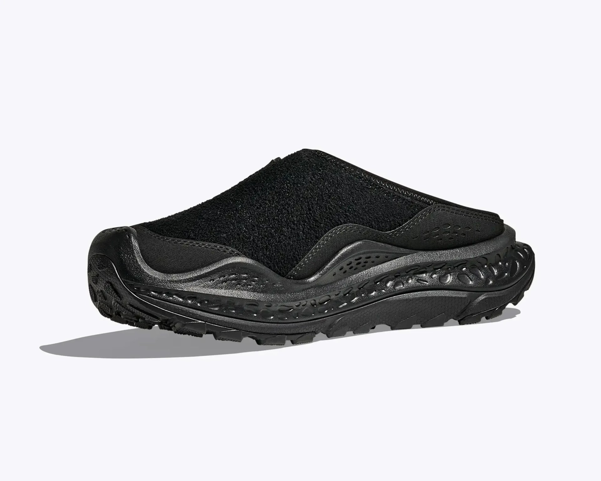 Black slip-on mule shoe with textured upper and thick sculpted sole.