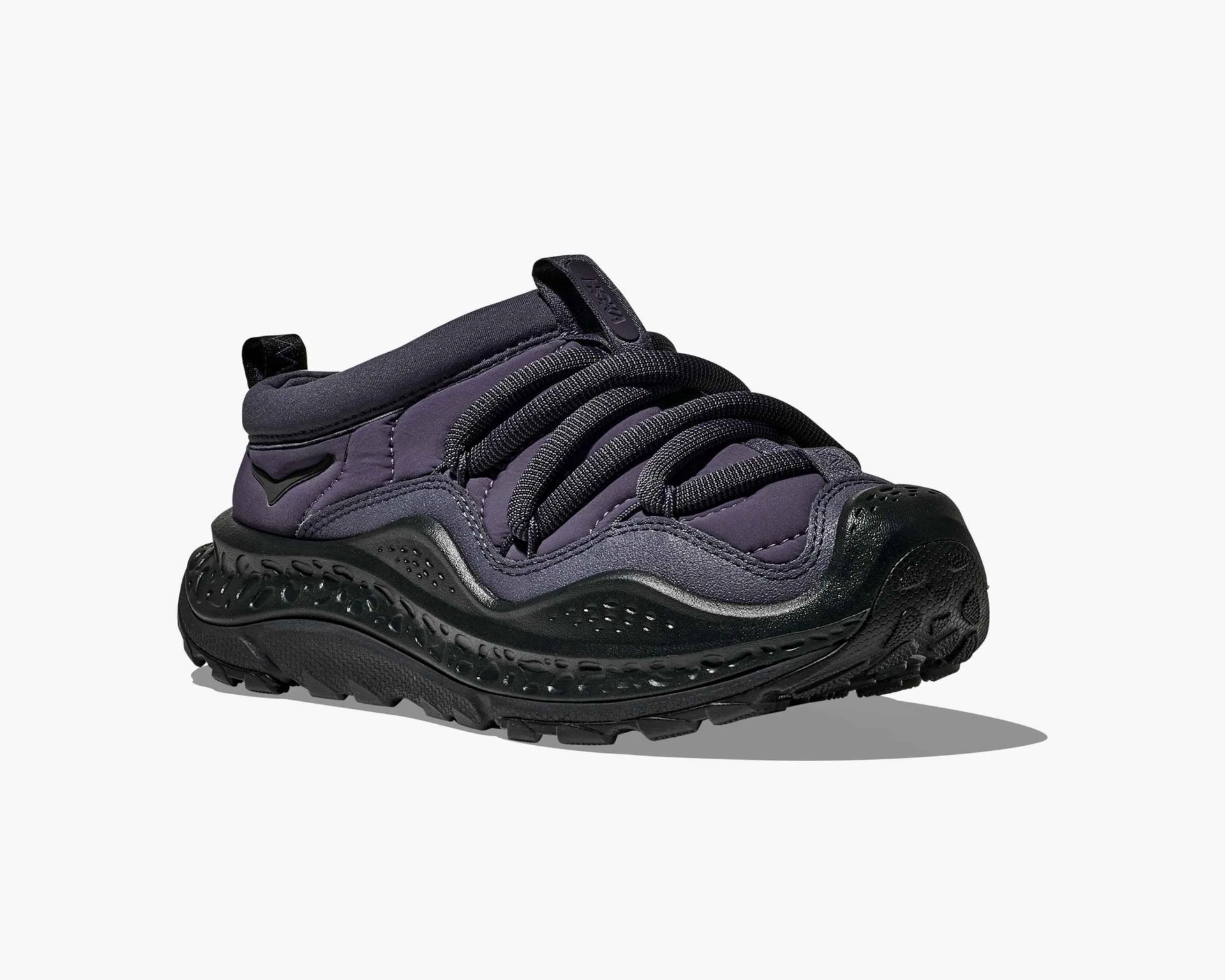 Black and dark gray sneaker with thick textured sole and large rounded laces on a white background.