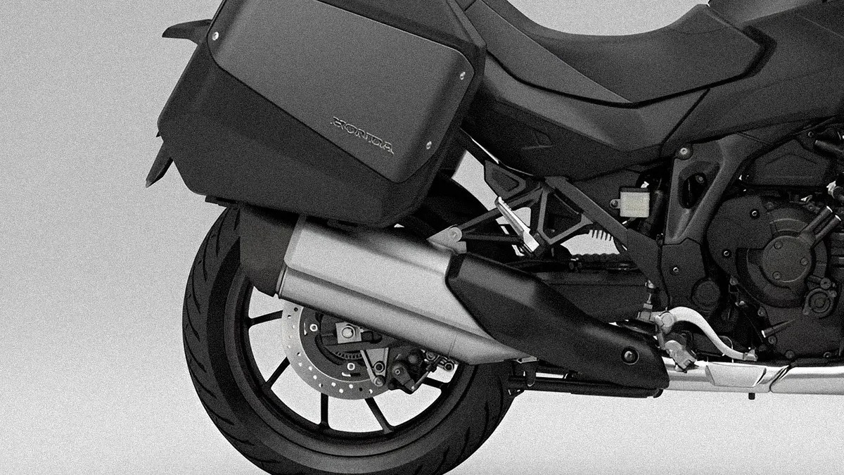 Rear section of a black Honda motorcycle showing the rear wheel, exhaust pipe, and side pannier.