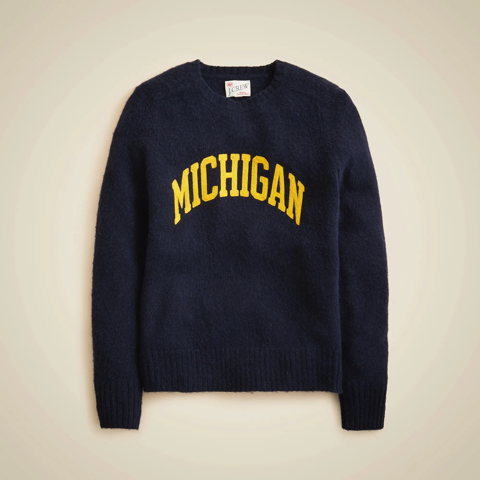 Navy blue crewneck sweater with yellow "MICHIGAN" text across the chest.