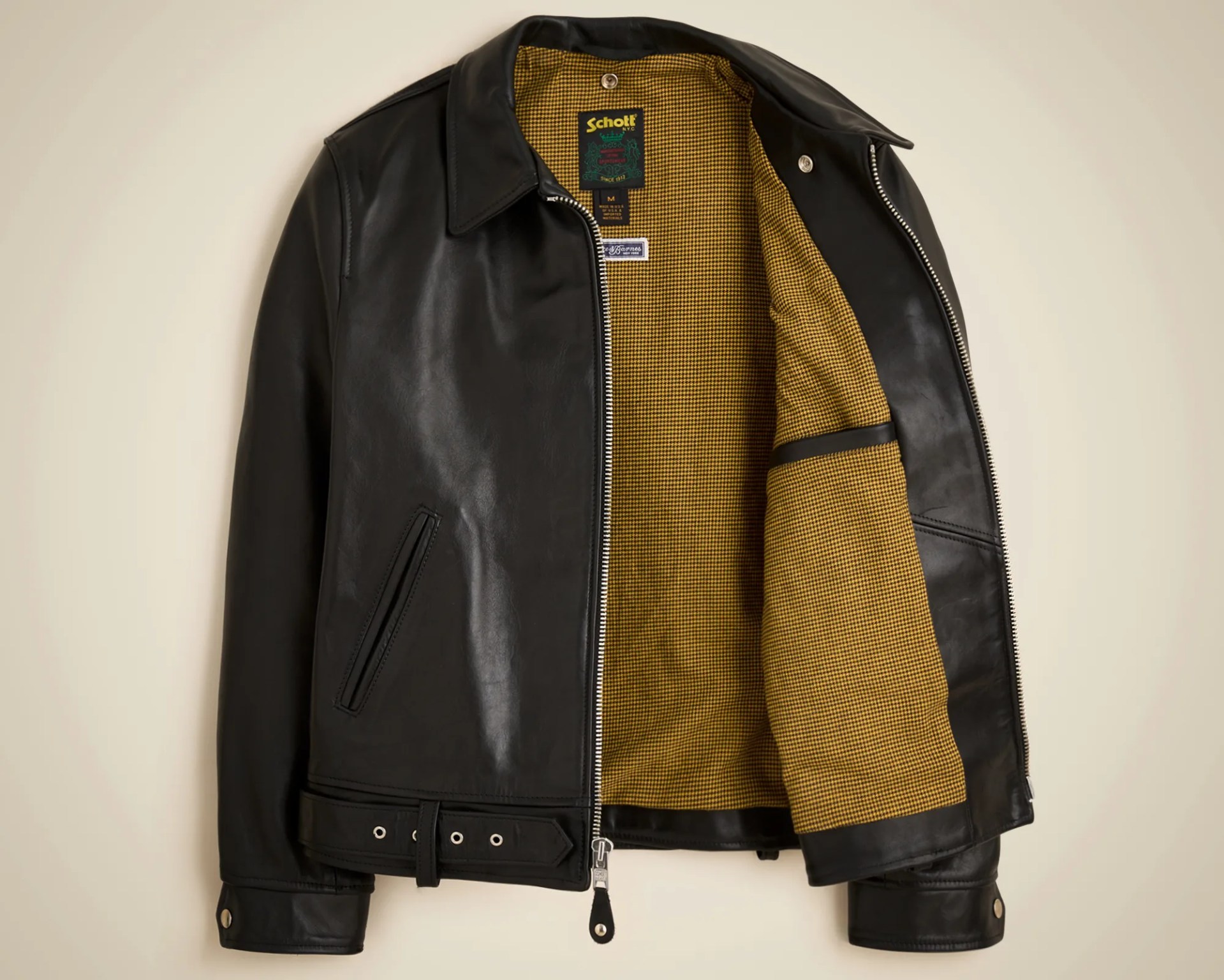 Black leather jacket with yellow checkered inner lining and silver zipper, laid flat.