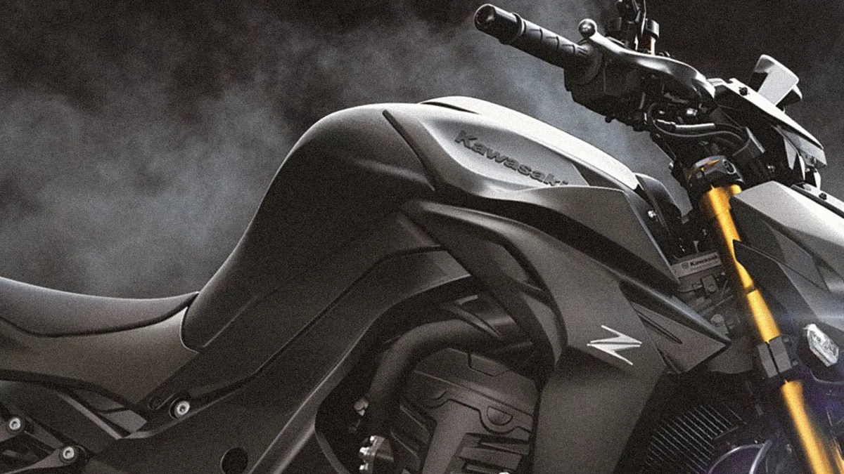 Close-up of a matte black Kawasaki motorcycle fuel tank and front fork with gold suspension.