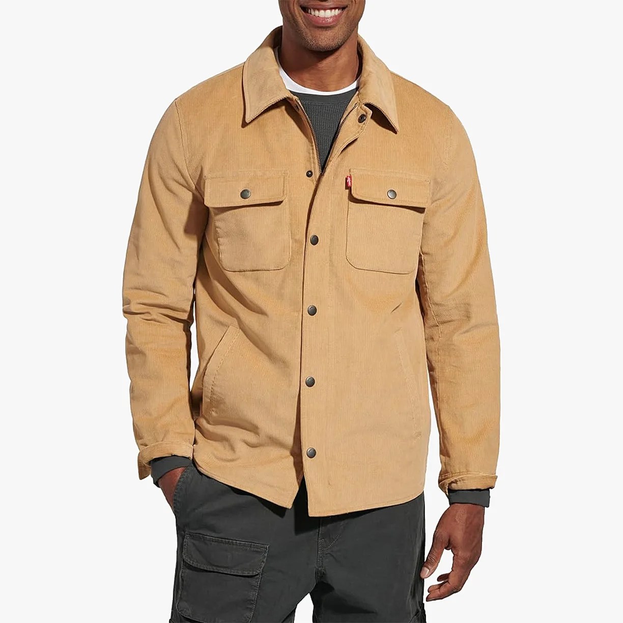 Tan corduroy jacket with snap buttons and flap chest pockets worn over a dark shirt.