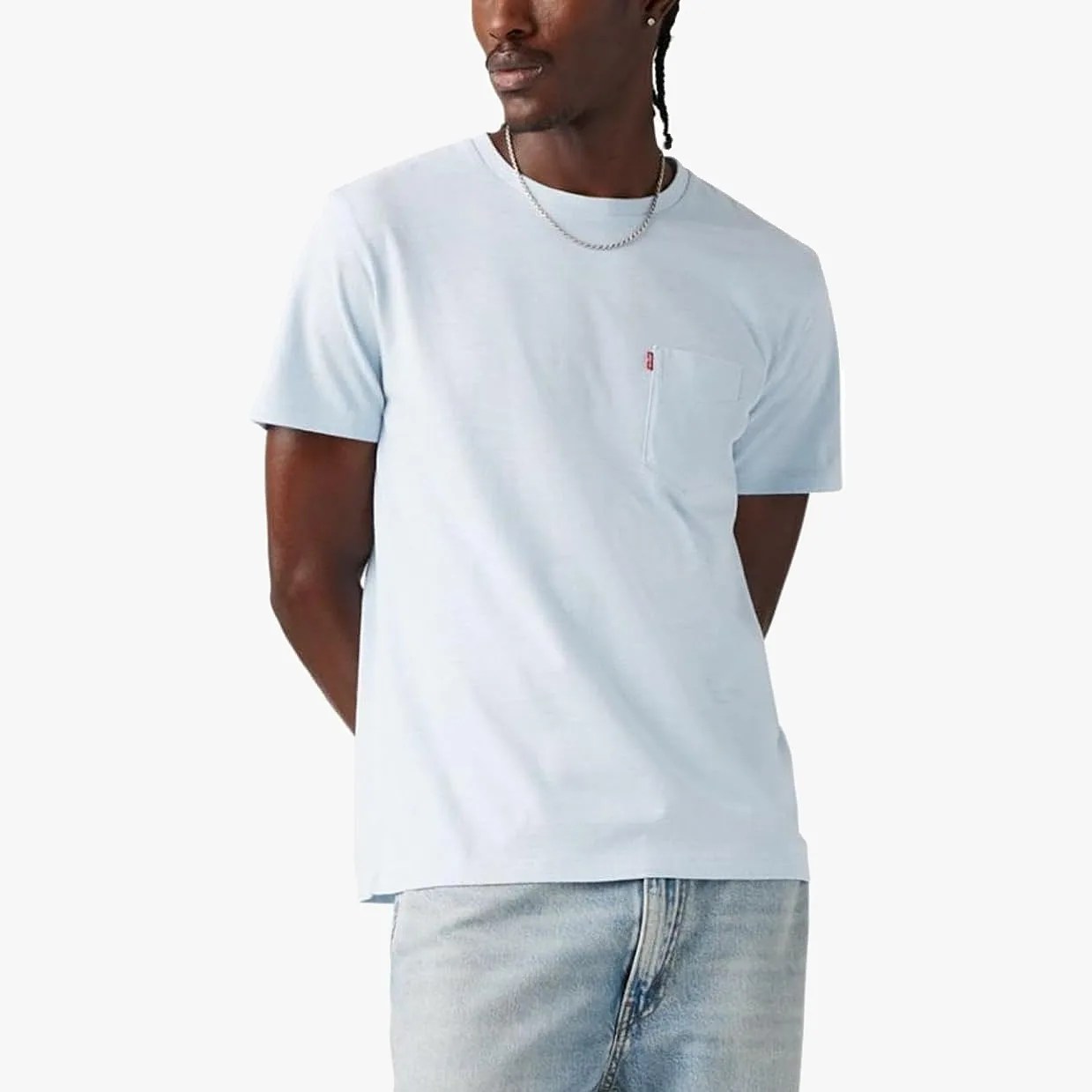 Light blue short-sleeve pocket t-shirt worn with light wash jeans.