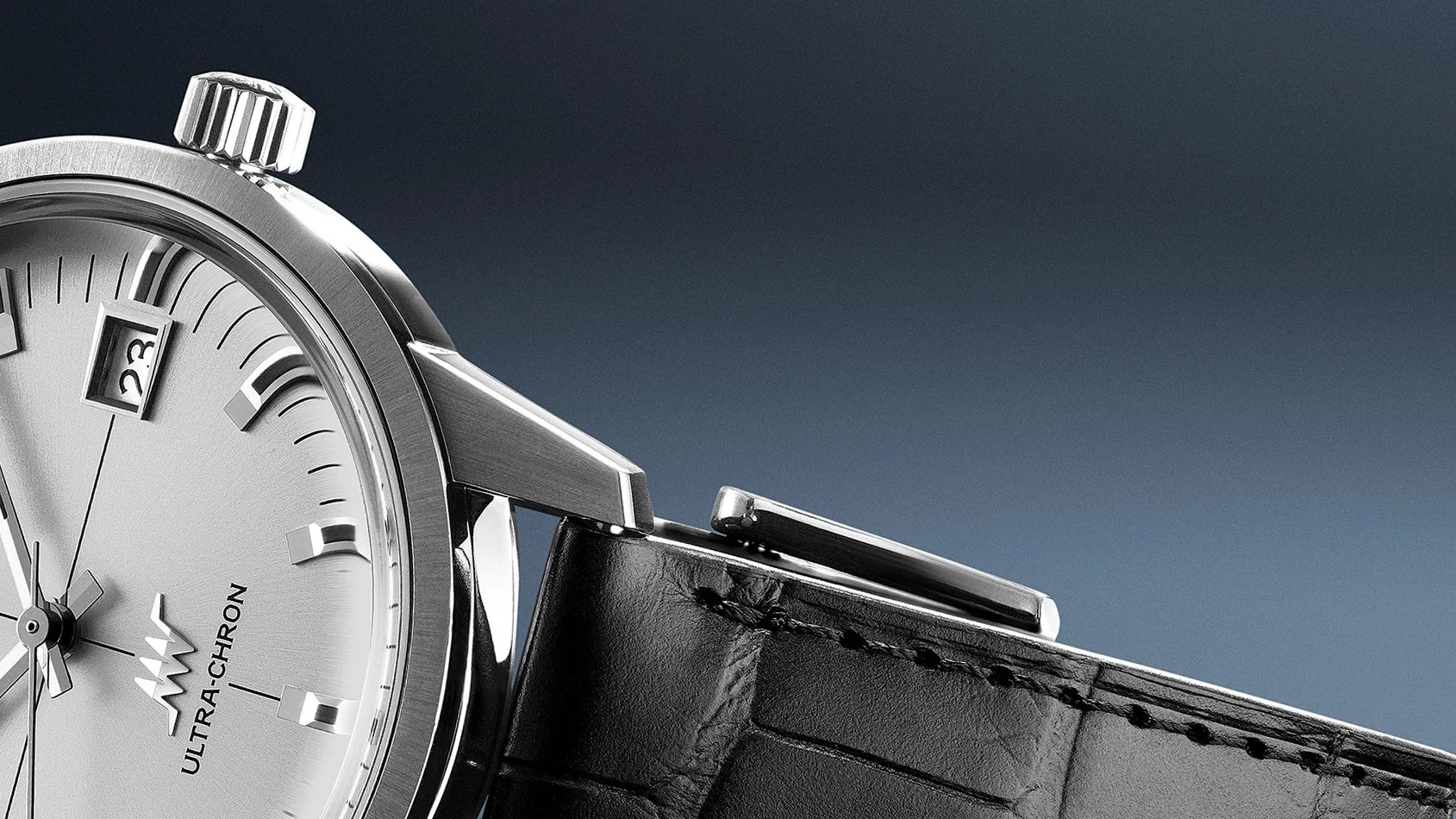 Close-up of a silver Ultra-Chron watch face with a date window and black leather strap.