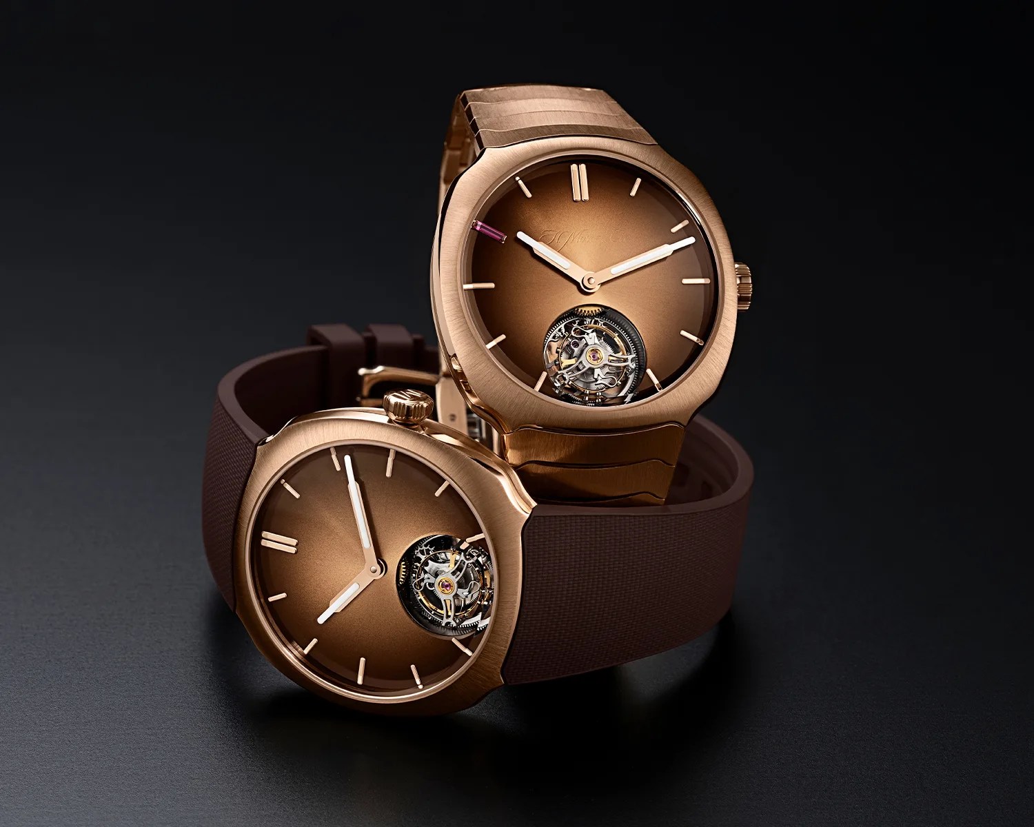 Two rose gold wristwatches with brown dials and visible tourbillon mechanisms, one with a metal bracelet and the other with a brown rubber strap.
