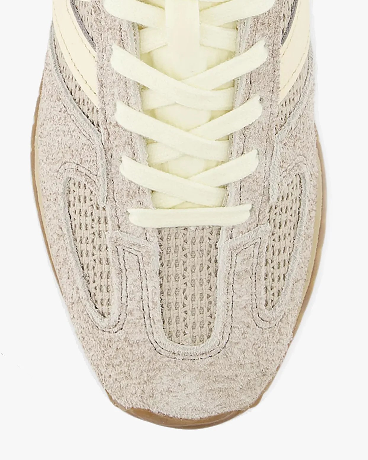 Close-up of beige suede and mesh sneaker toe with cream-colored laces.