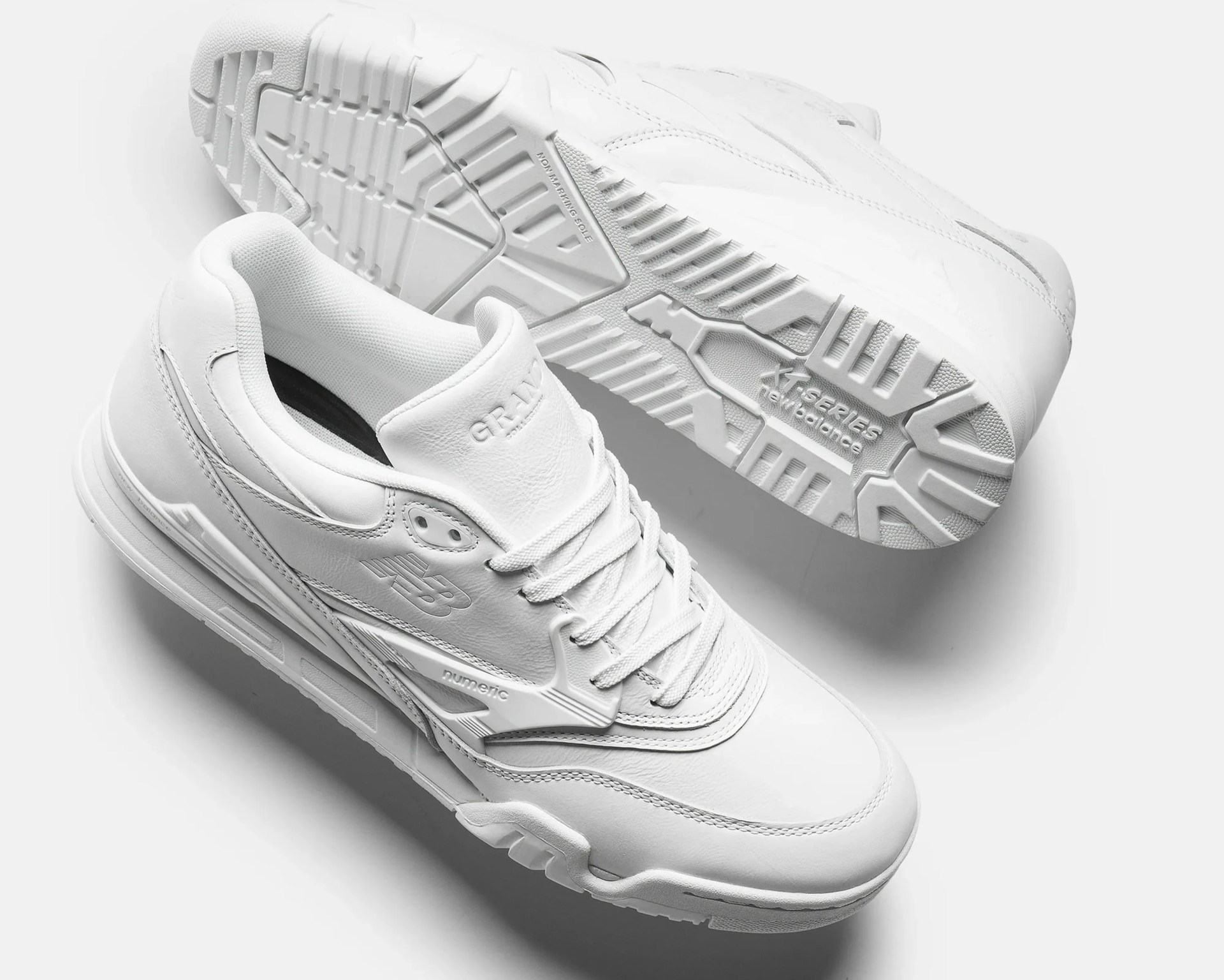 Pair of white New Balance numeric GR-1V sneakers with textured soles and lace-up design.