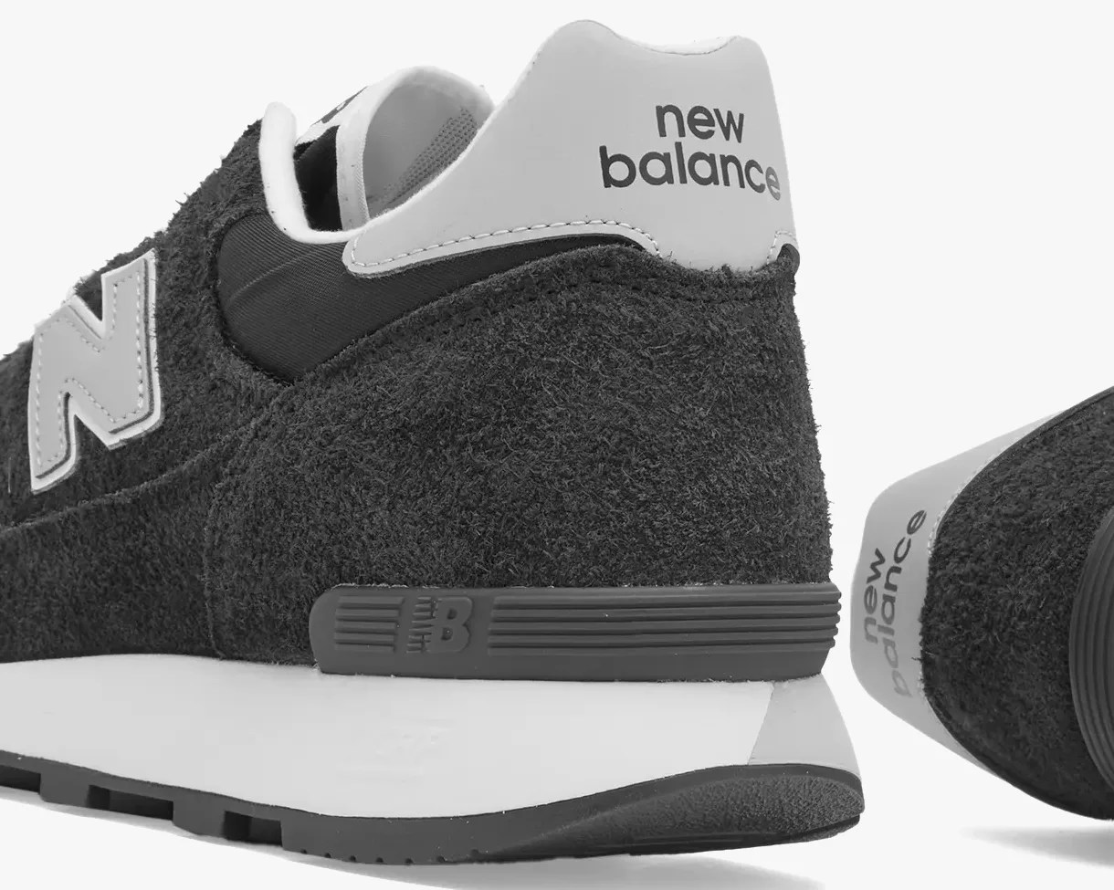 Close-up of black New Balance sneaker heel with white midsole and "new balance" text on the back tab.