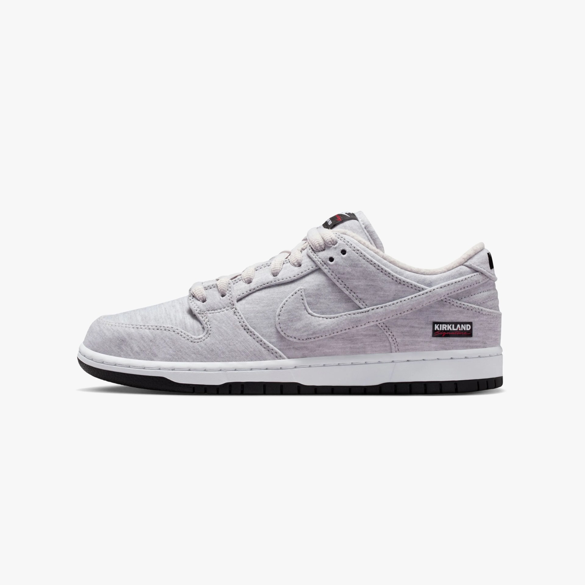 Light gray low-top sneaker with white midsole, black outsole, and "Kirkland Signature" label on the heel.