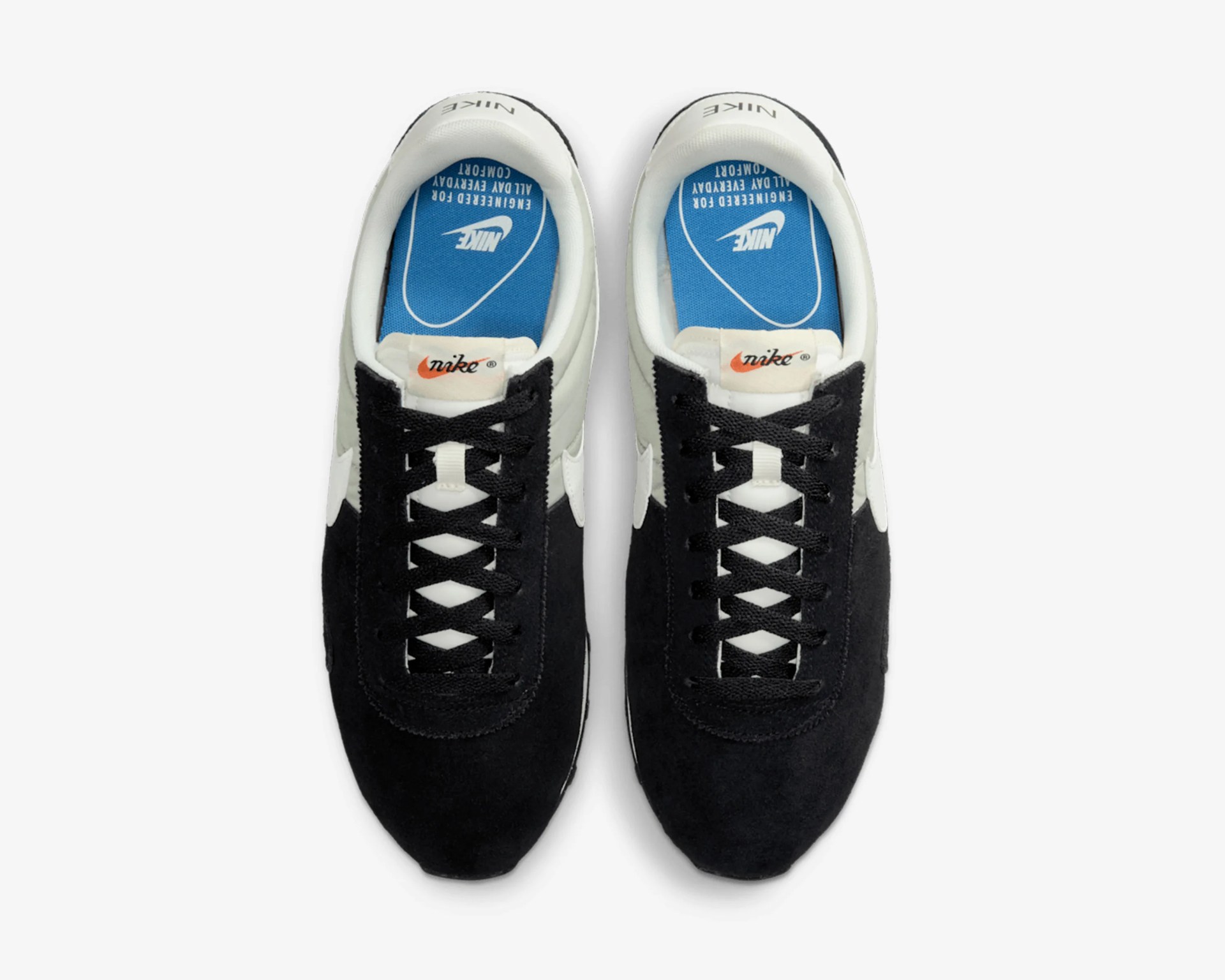 Pair of black and white Nike sneakers with blue insoles and black laces, viewed from above.