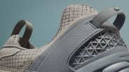 Close-up of a gray sneaker heel with a geometric lattice pattern and fabric pull tabs.