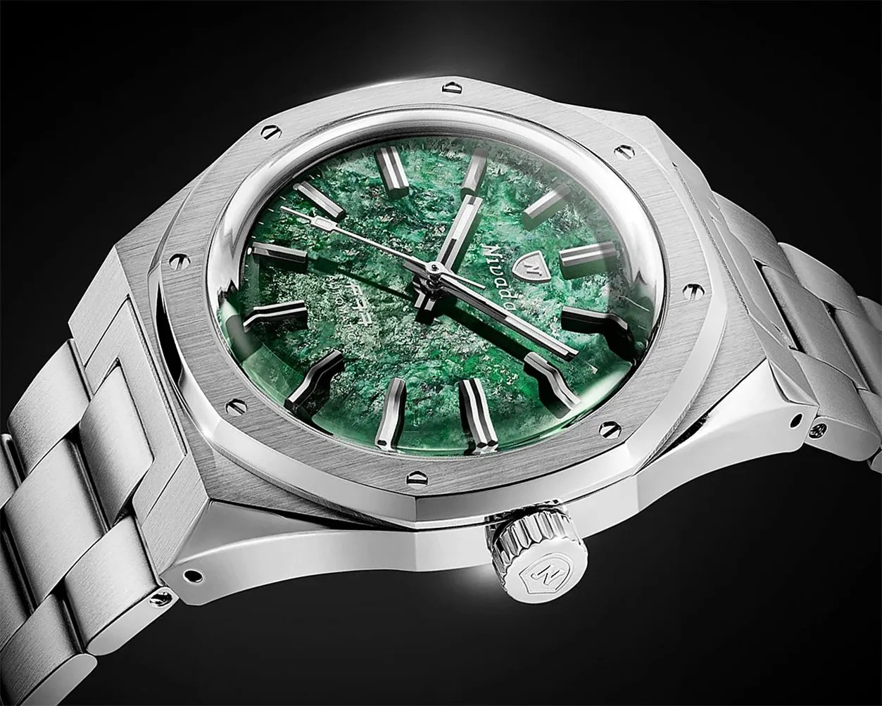 Silver metal wristwatch with a textured green dial and bold silver hour markers on a black background.