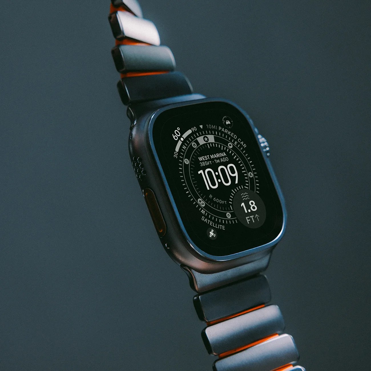 Smartwatch with a black metal link band displaying a digital compass and time 10:09 on screen.