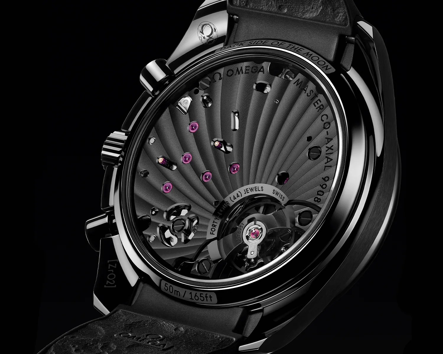 Close-up of the back of an Omega Dark Side of the Moon watch showing the intricate black movement with purple jewels and "50m / 165ft" water resistance marking.