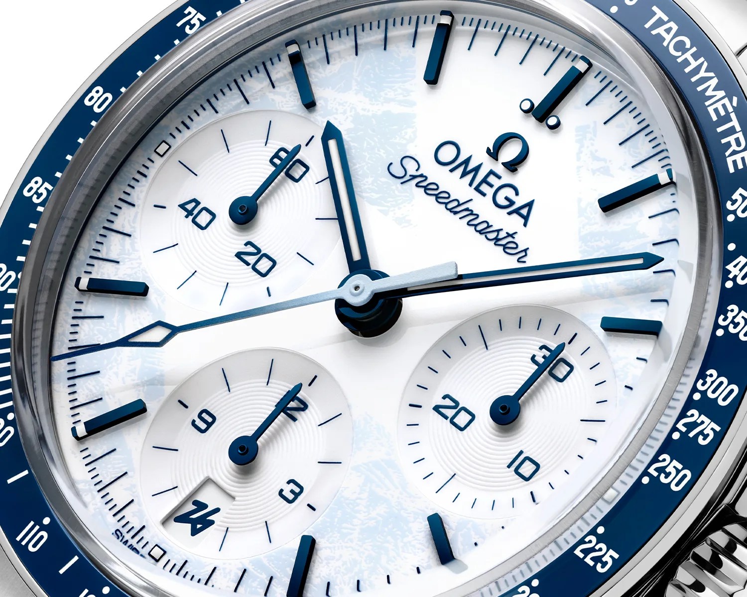 Close-up of an Omega Speedmaster watch face with white dial, blue markers, and tachymeter scale on the bezel.