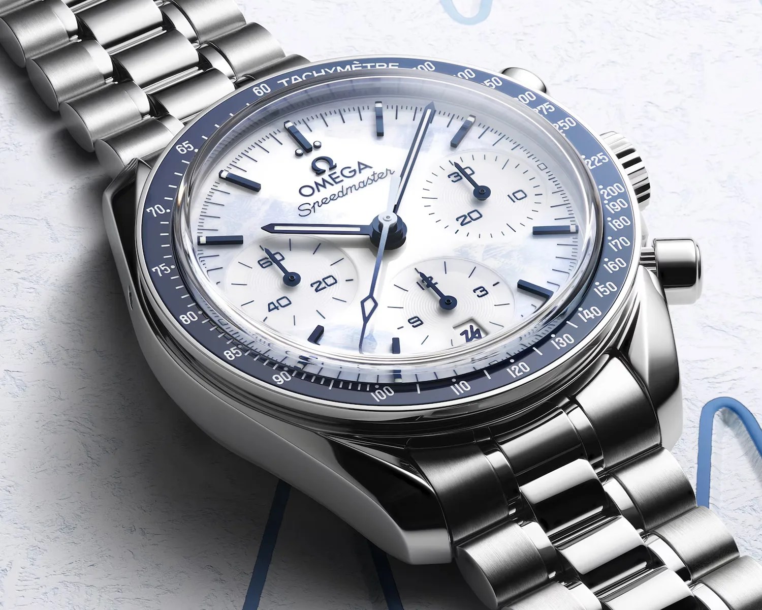 Silver Omega Speedmaster watch with white dial, blue tachymeter bezel, and stainless steel bracelet.