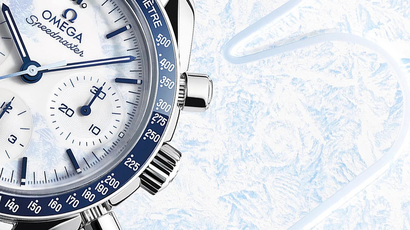 Close-up of an Omega Speedmaster watch with a white and blue dial and a blue tachymeter bezel.