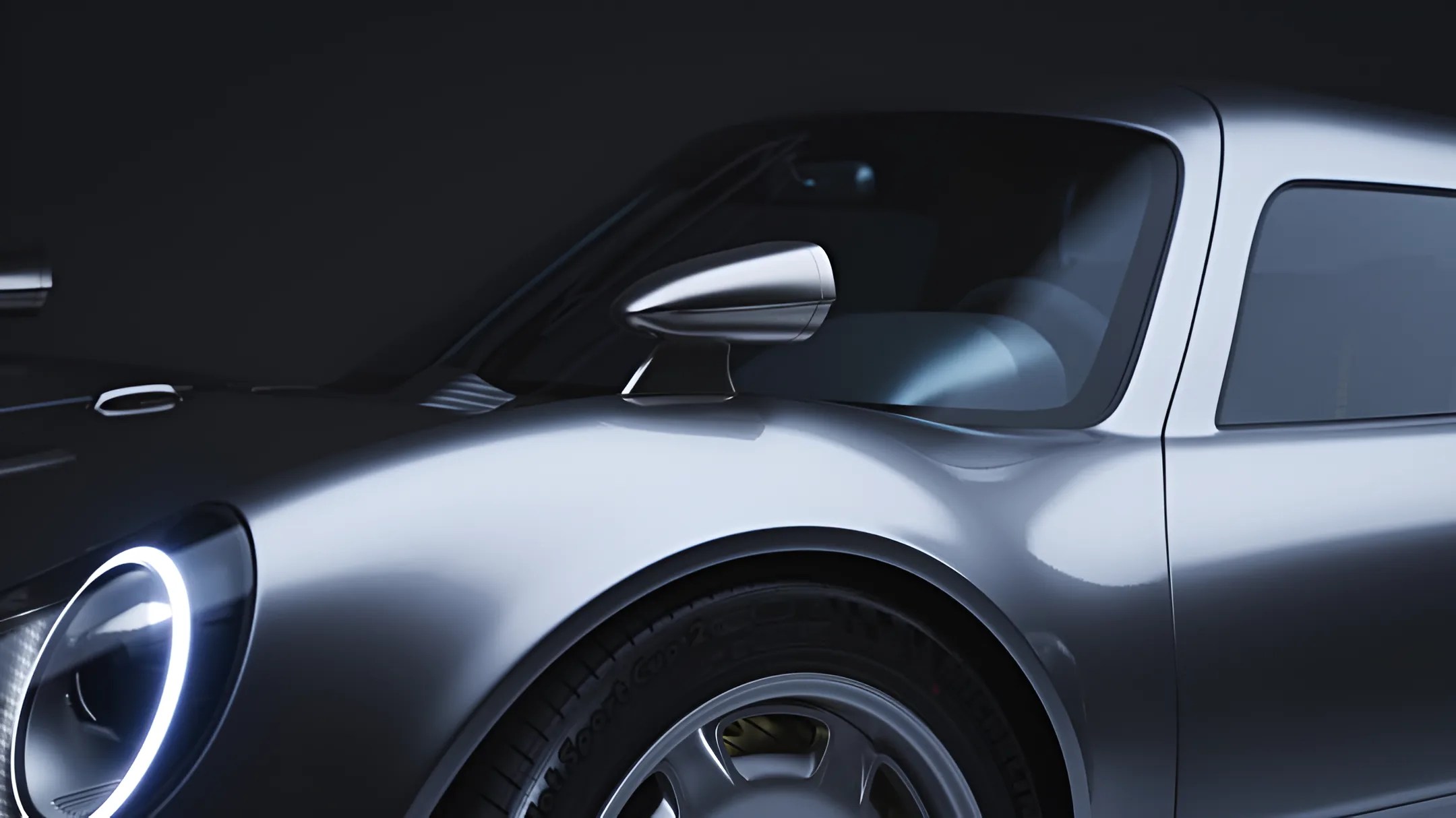 Close-up of a silver sports car's front left side, showing a round LED headlight, side mirror, and wheel.
