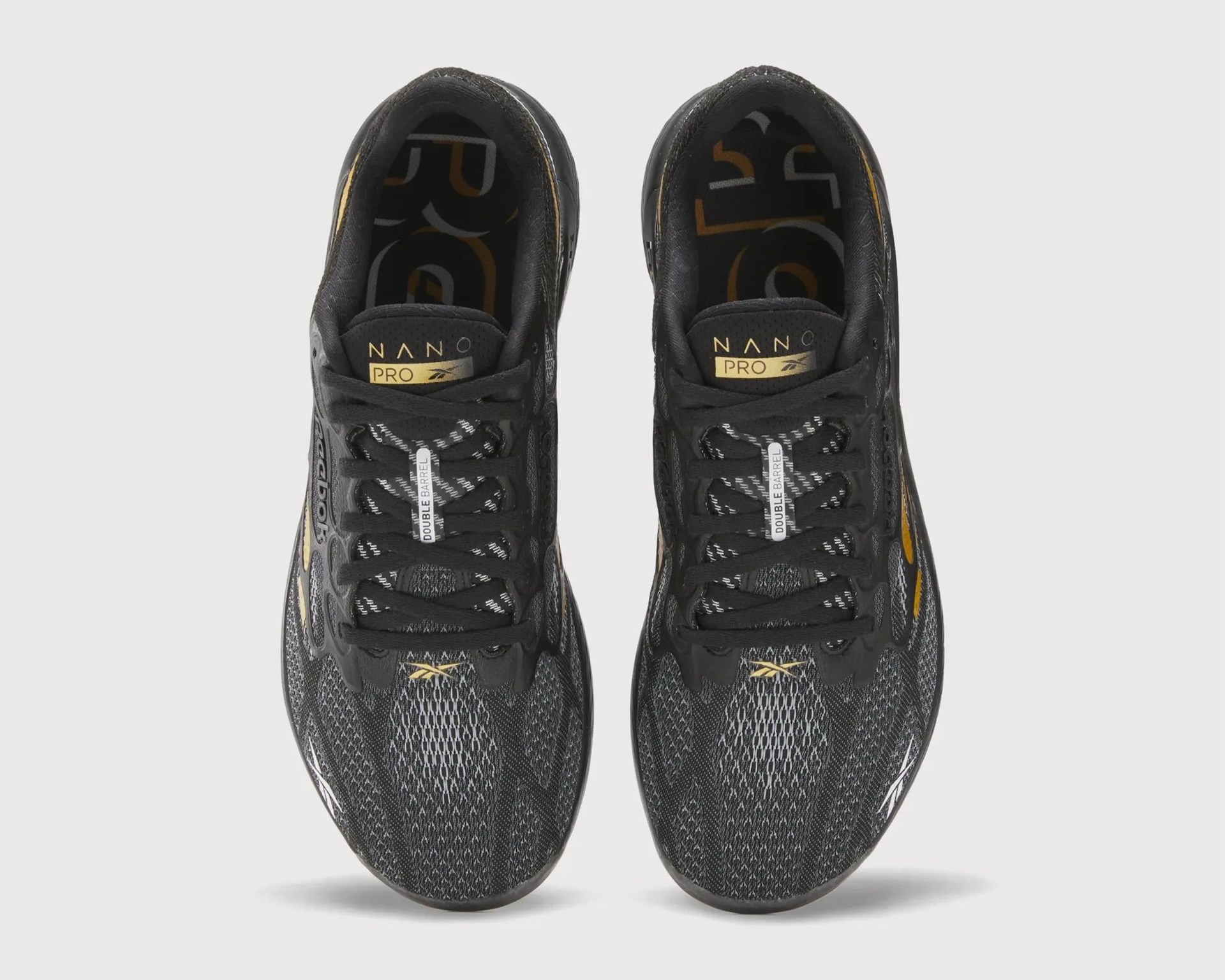 Pair of black and gold Reebok Nano Pro athletic shoes viewed from above.