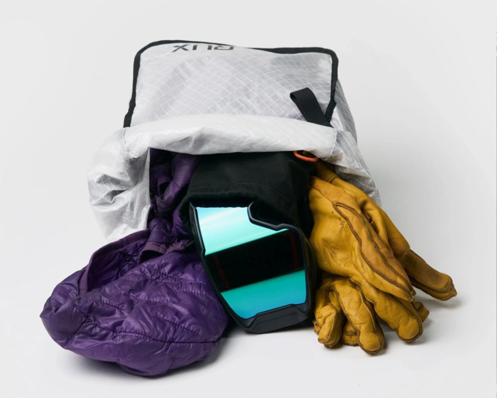 White roll-top backpack with black trim containing purple insulated gloves, yellow leather gloves, and blue-tinted ski goggles.