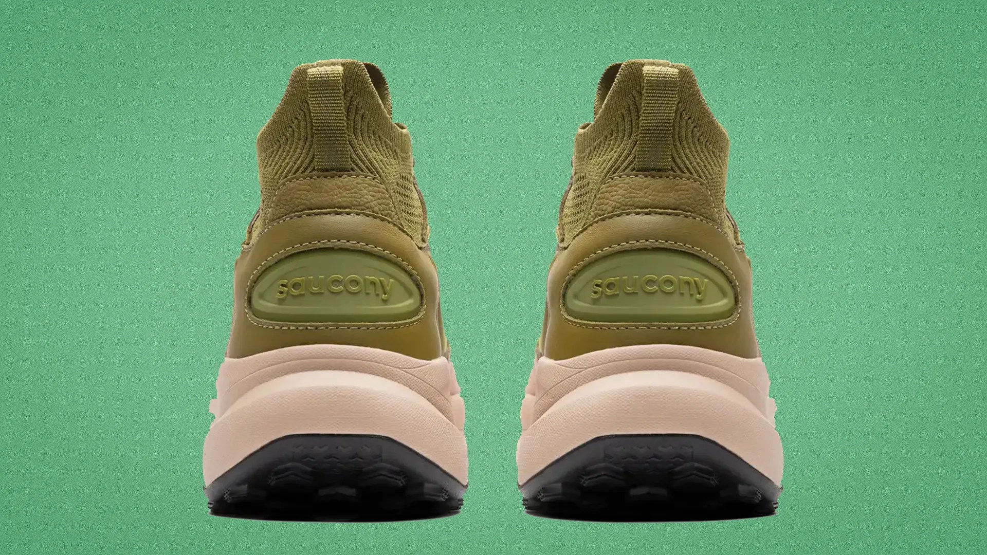 Pair of olive green Saucony sneakers shown from the back with beige midsoles and black outsoles on a green background.